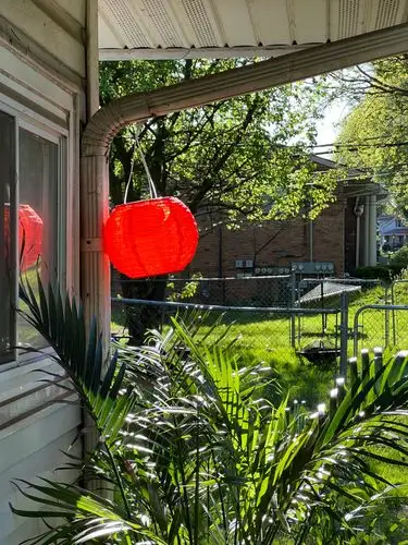 Vibrant red lantern, glowing bright in the sun.
